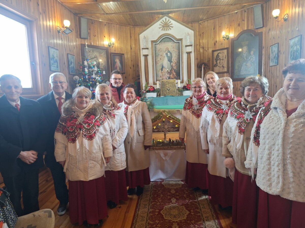 Cały zespół Jargocianie, Marek Szulikowski i mieszkanka z Szyperek pozują na zdjęcie w kaplicy pw. Narodzenia Najświętszej Maryi Panny w Szyperkach