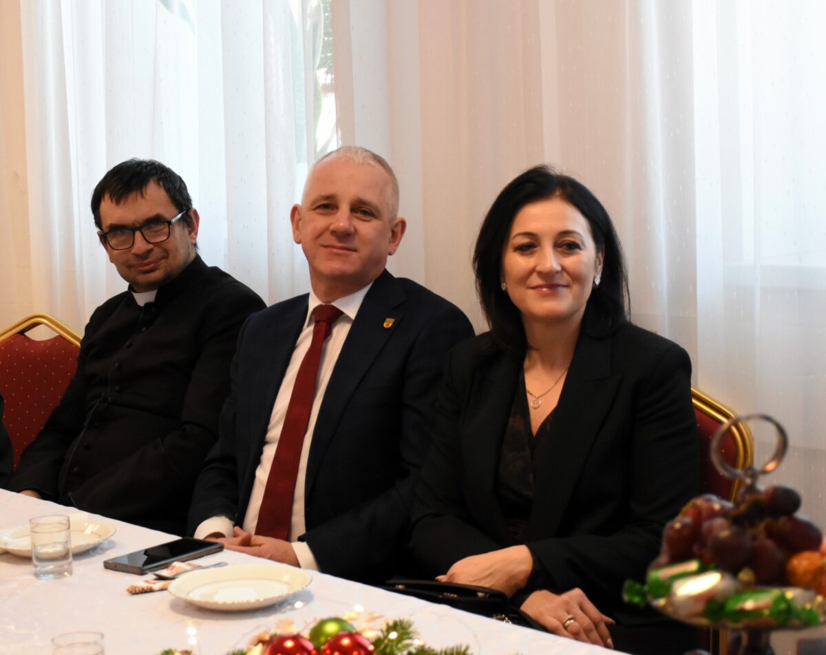 DSC_8871 Ksiądz proboszcz Robert Capała siedzi koło Pana Wójta z żoną i patrzą na objektyw z uśmiechem
