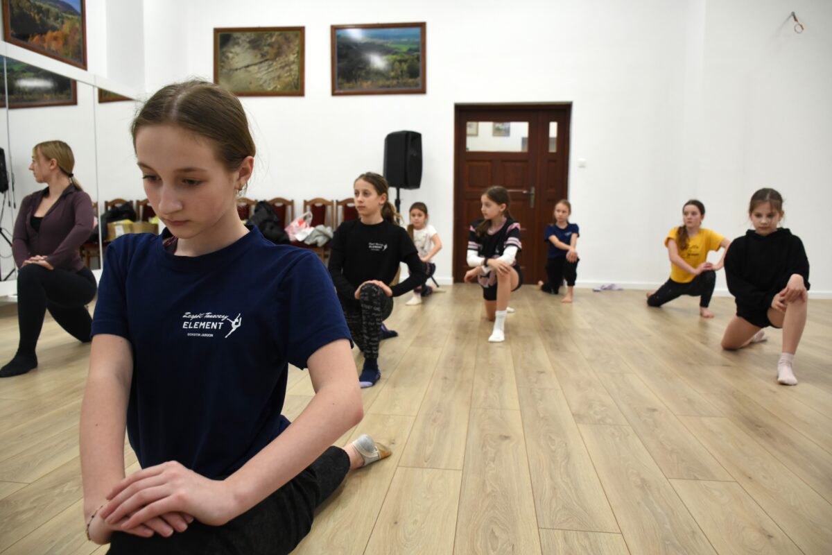 dziewczyny rozciągają się wykrokiem z oparciem kolana na ziemi