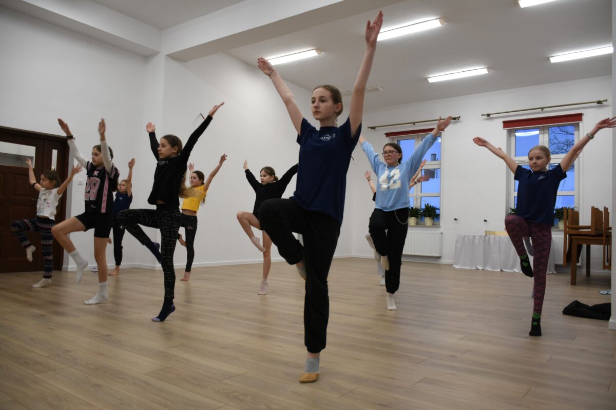 Dziewczyny stoją na jedną nogę rozciągają się do góry