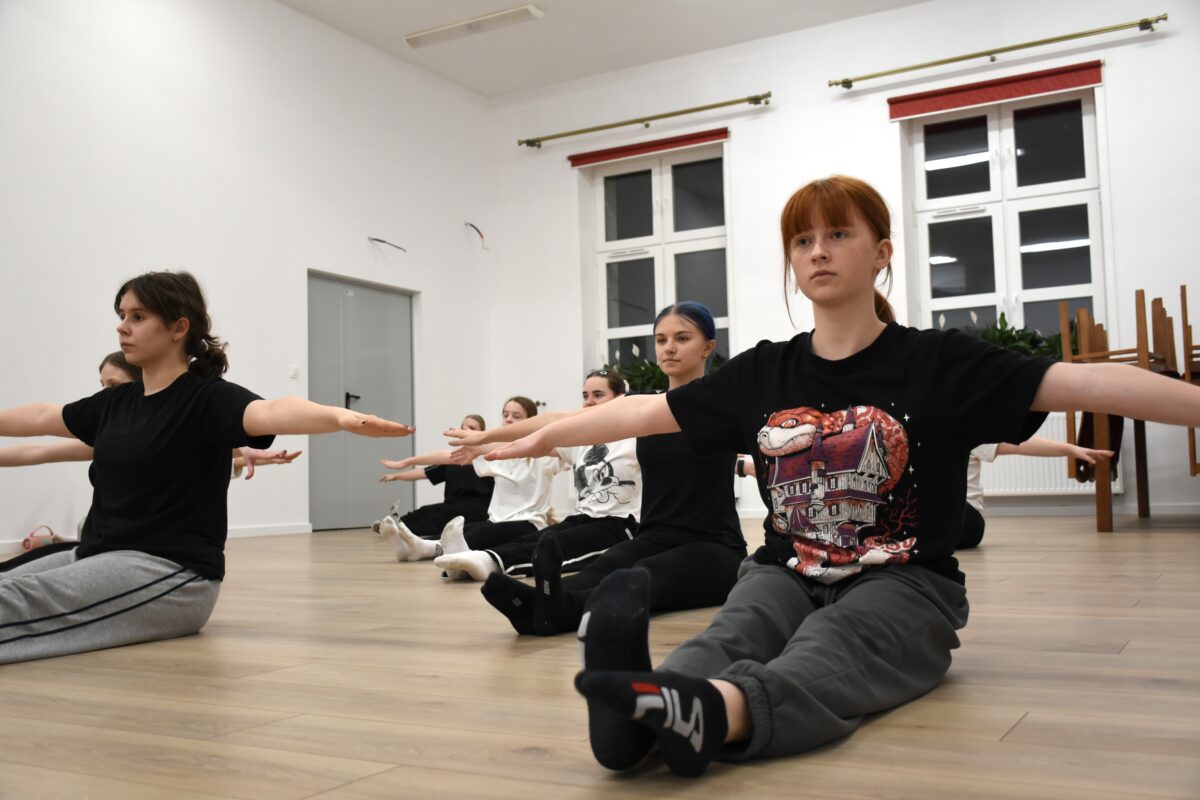 Dziewczyny siedzą w siadzie prostym