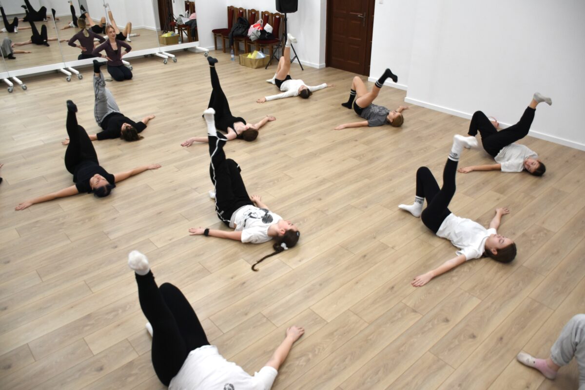 Widać prawie wszystkie dziewczyny z góry jak ćwiczą na leżąco, nogi do góry