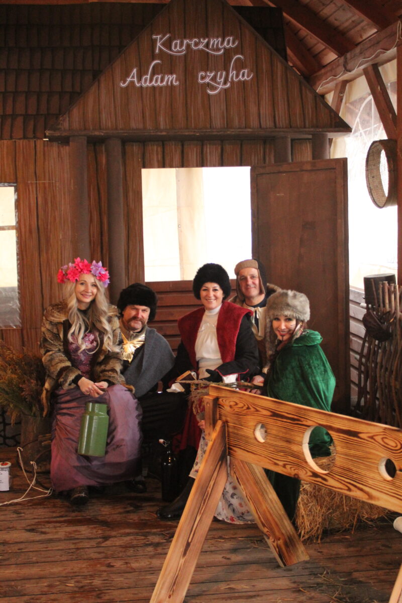 Osoby pozują z panem Wójtem z Gminy Jarocin i żoną przy dekoracji Karczmy Adama Czycha