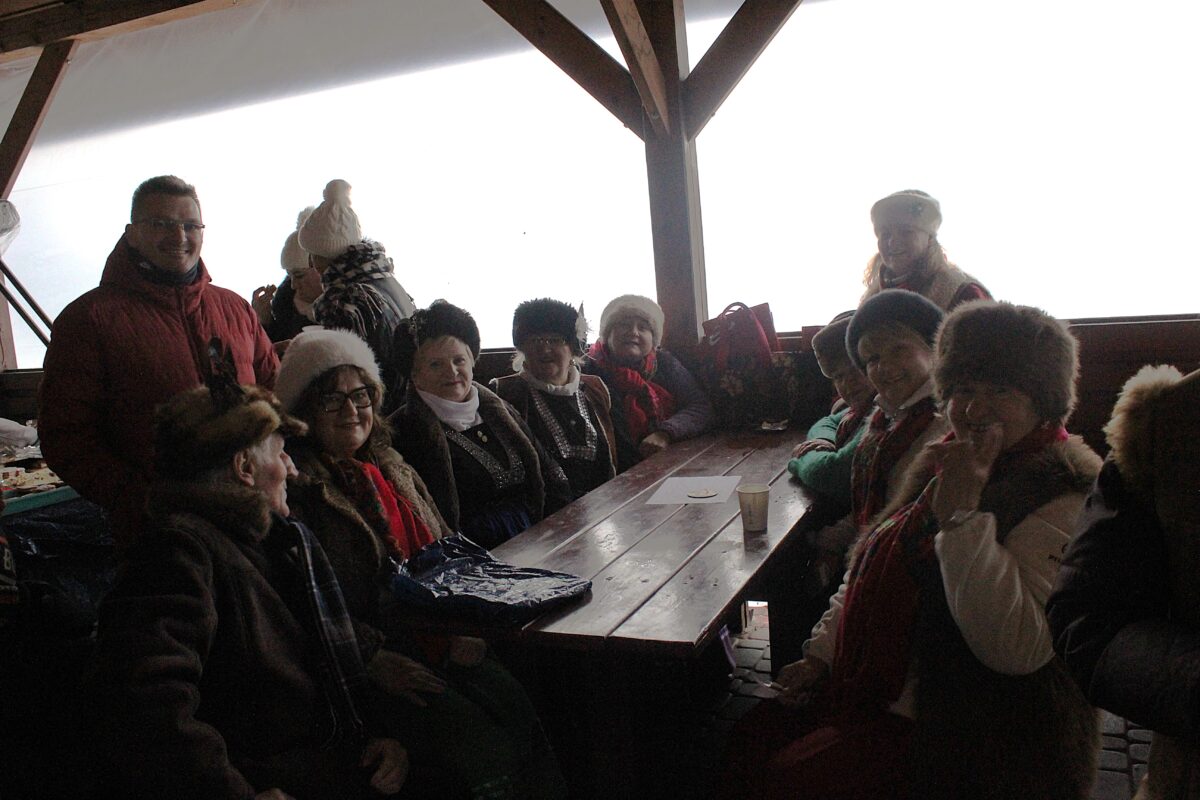 Zespół Jargocianie i Marek Szulikowski siedzą i stoją przy stole