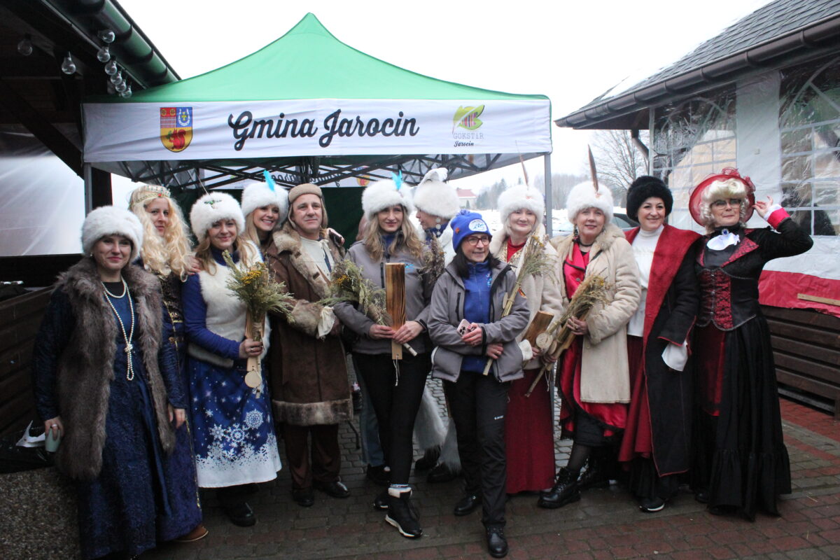 Pełna grupa ludzi i morsów posuje do zdjęcia przed namiotem Gminy Jarocin