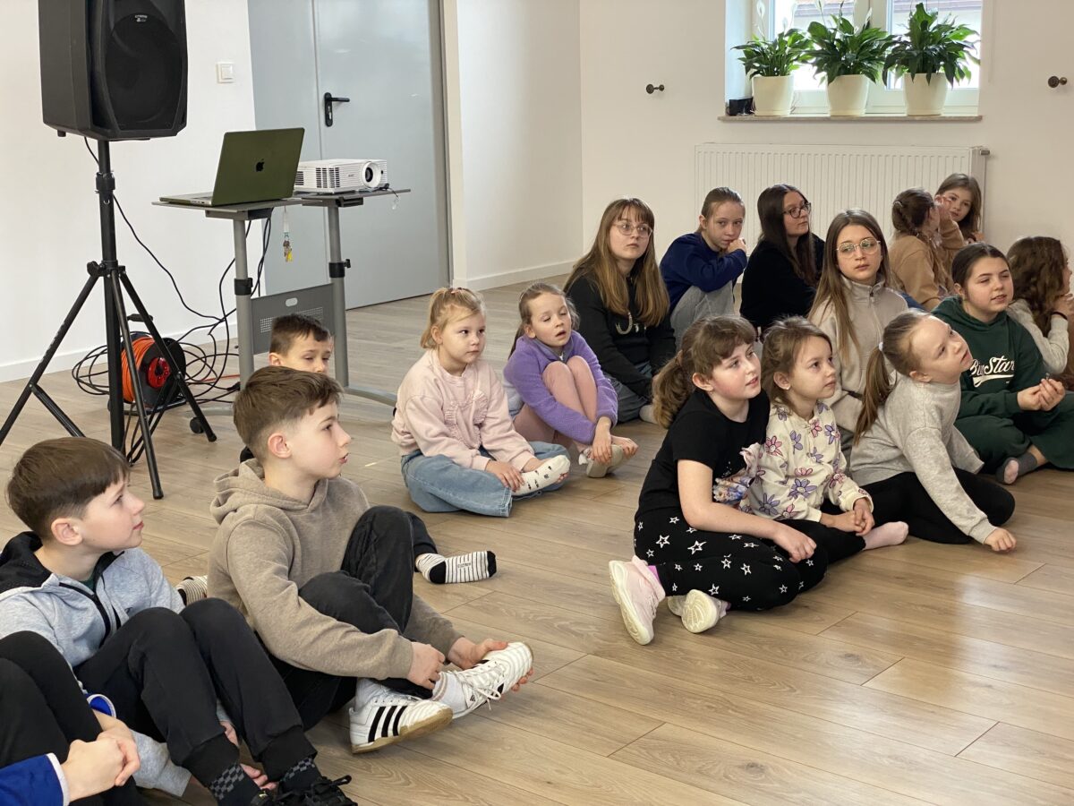 dzieci słuchają grzecznie siedząc