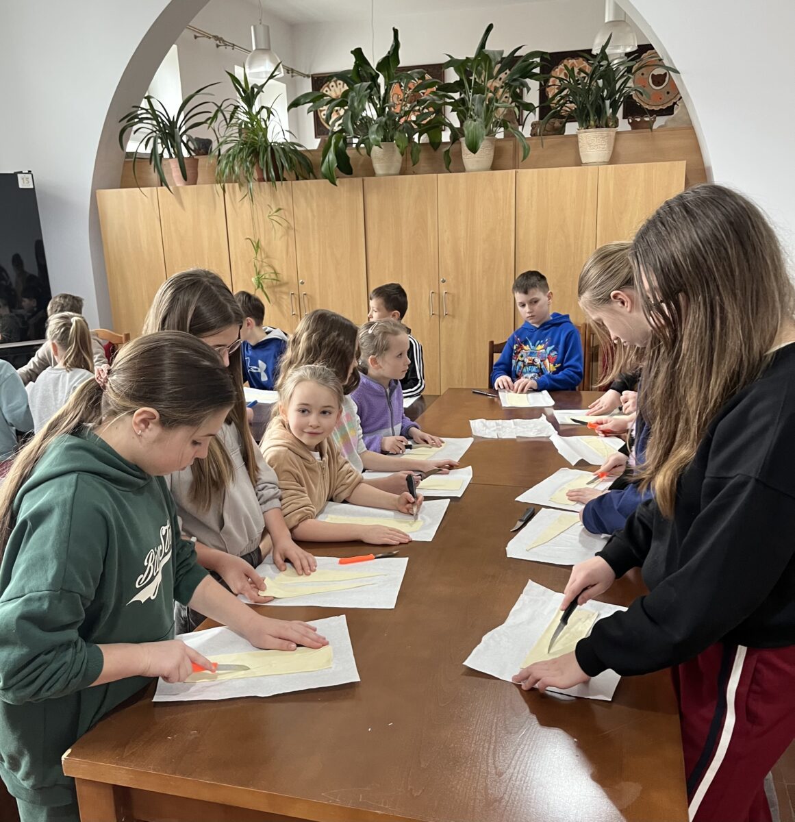 Dzieci stoją w kuchni przed kawałkami z ciasta francuskiego