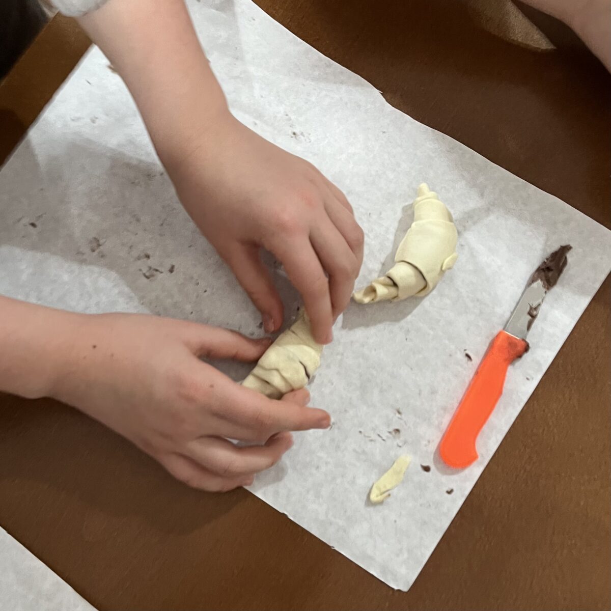 Dziecko poprawia swoje dwa croissanty