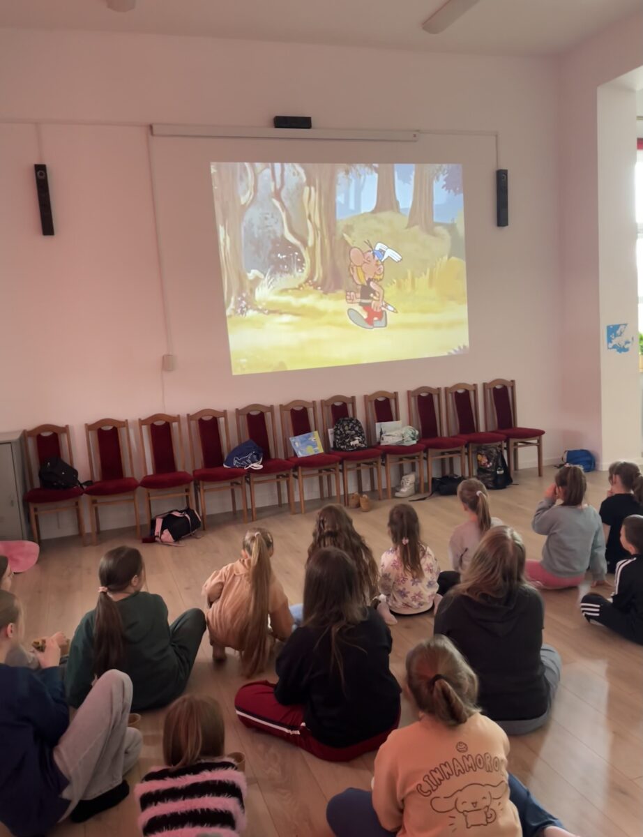 Dzieci siedzą oglądając film Asteriks