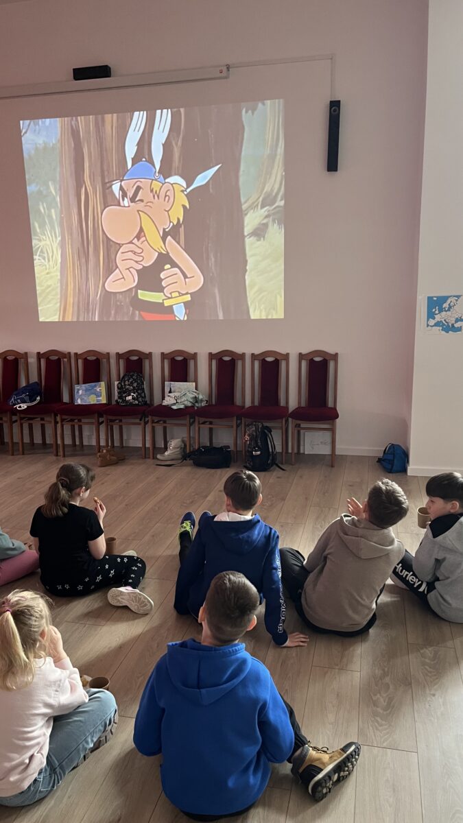 Dzieci siedzą oglądając film