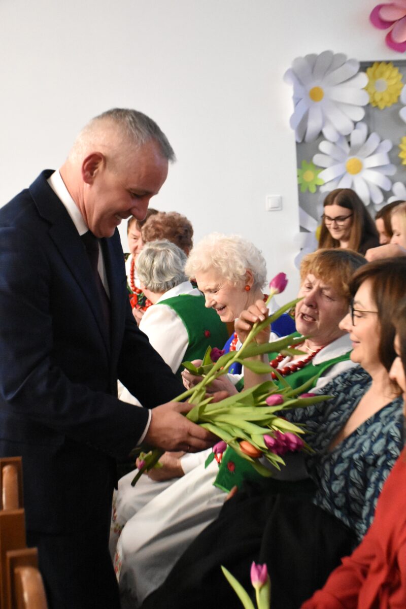 Pan Wójt Tomasz Podpora daje kwiatek dla każdej kobiecie