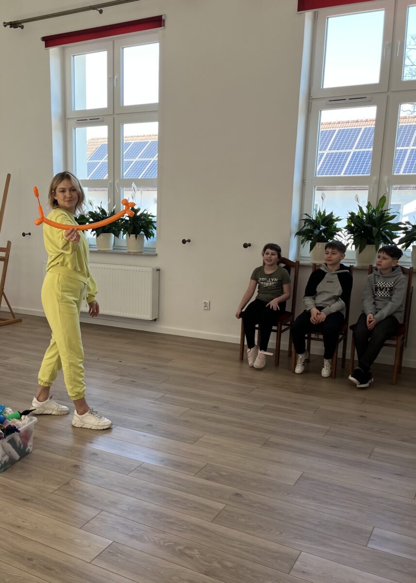 Pani z „Balonowej fotki” pokazuje długi piesek który zrobiła przed dziećmi