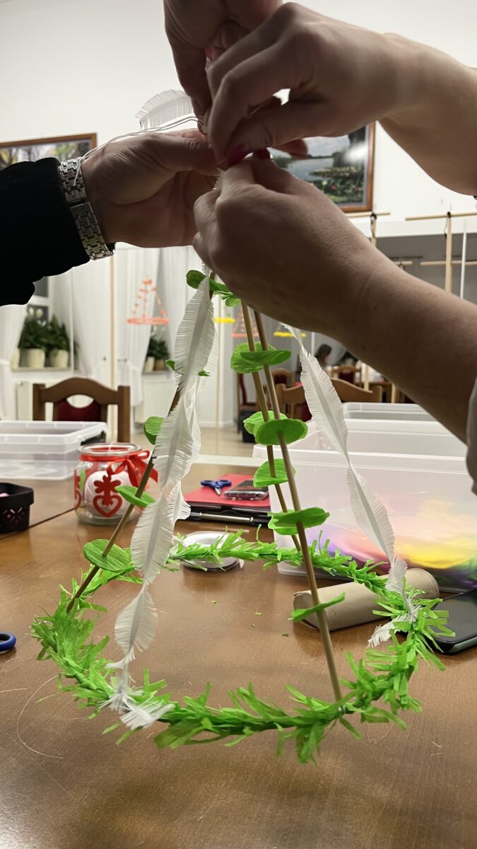 Dwie osoby wiążą pająk, już można go podnieść