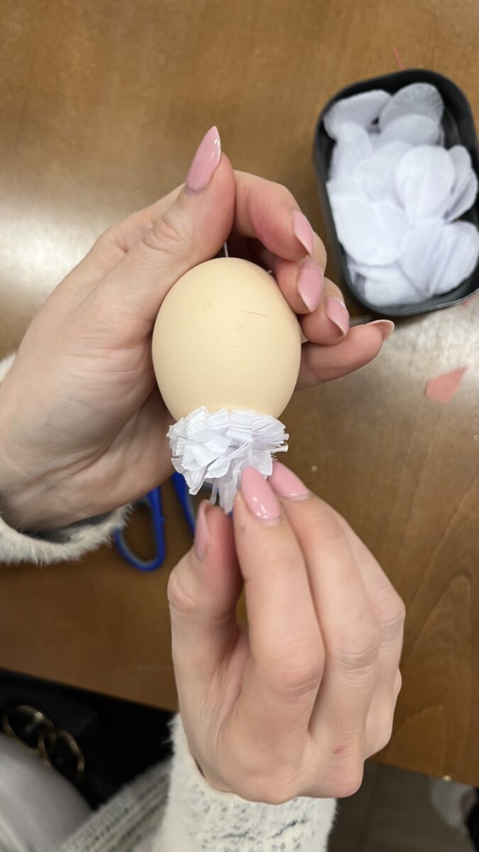 Jedna osoba dodaje papierki z jajkiem