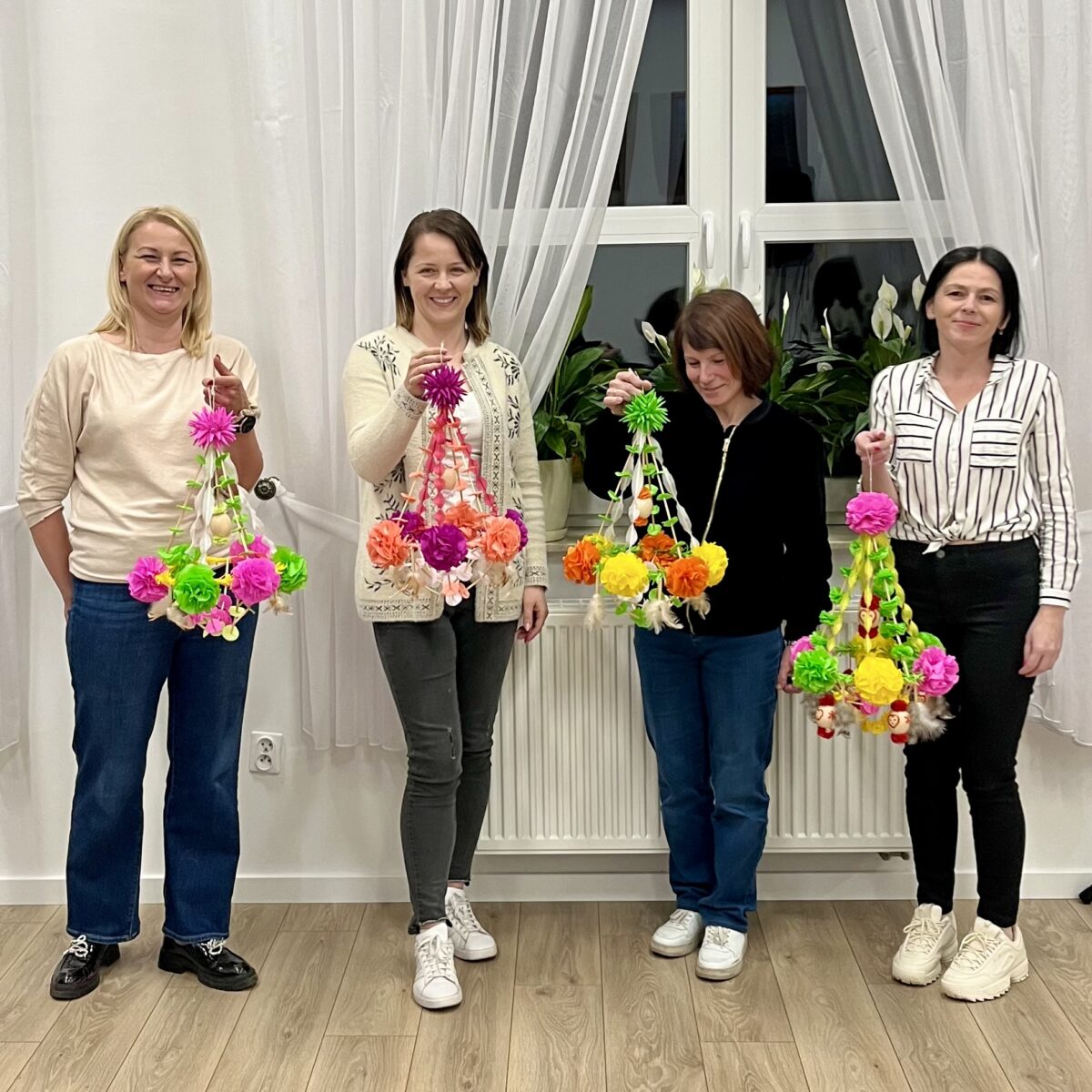 Pani instruktorka z zawodnikami uśmiechnięte, pozują z własnym pająkiem ludowym