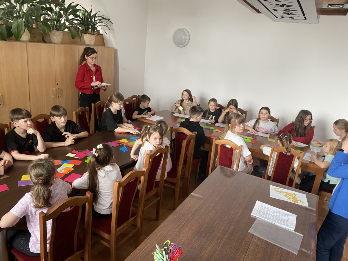 Dzieci w kuchni siedzą i patrzą na pani Agate