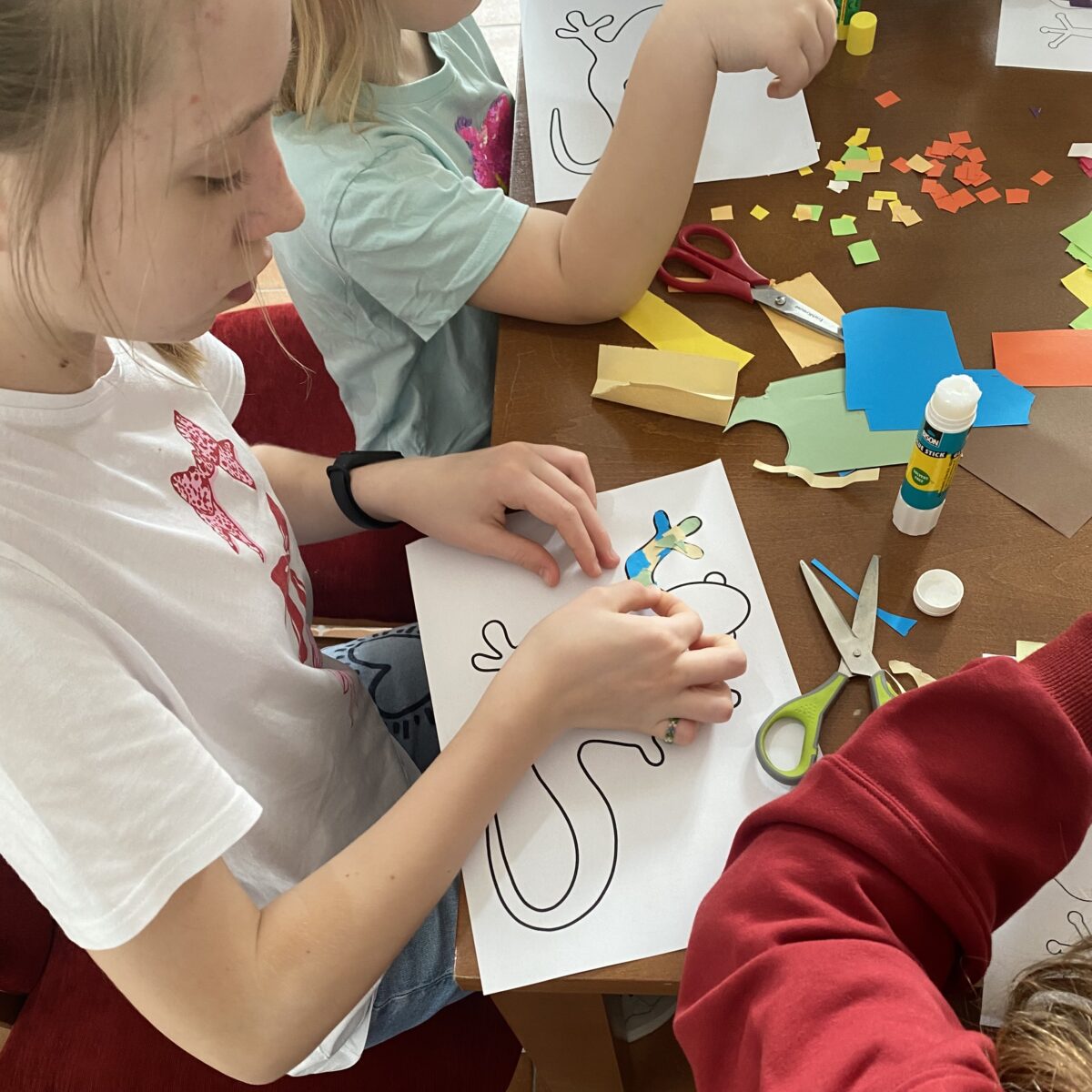 Sara przykleja papierki na jaszczurke