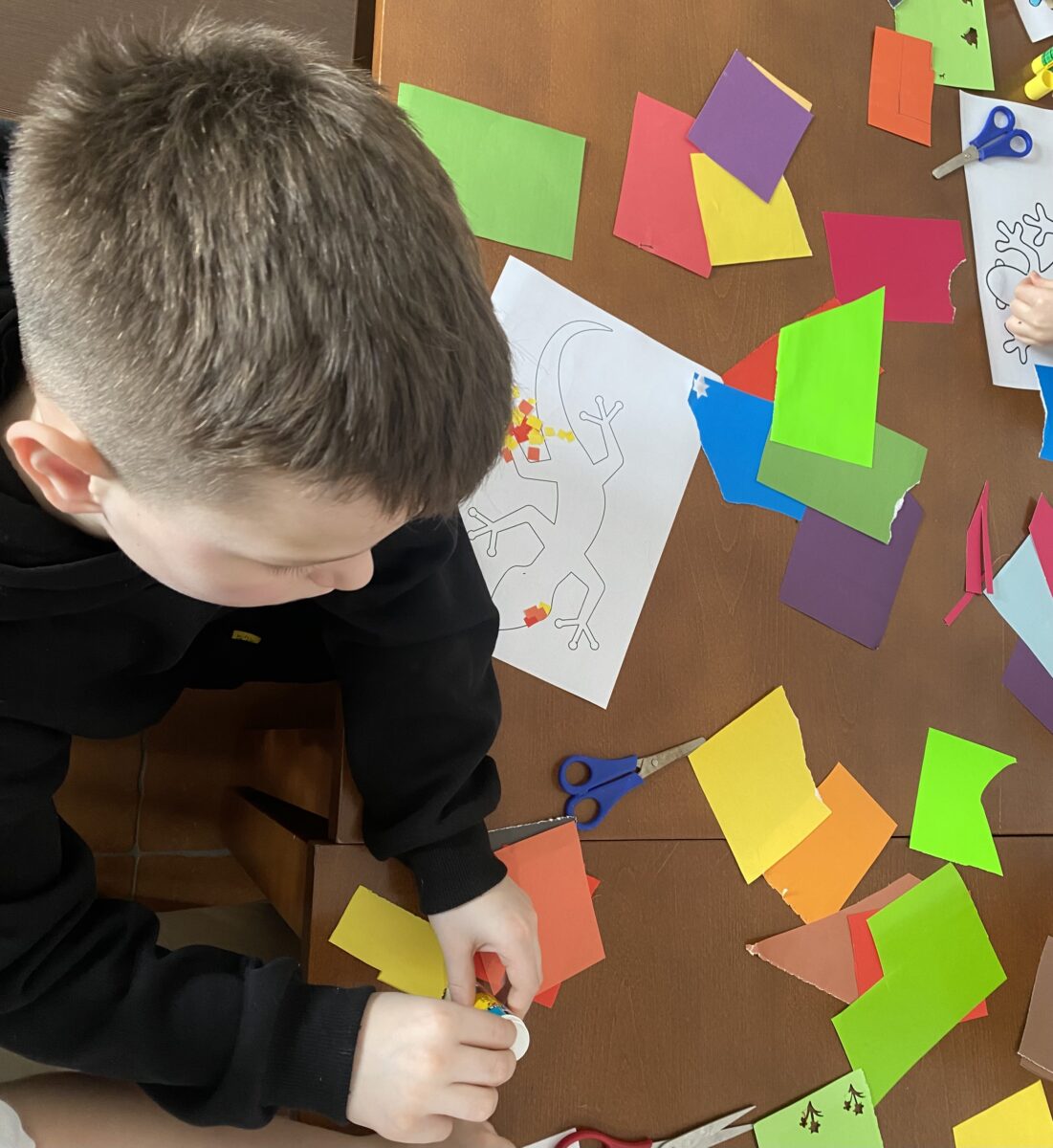 Dominik nakłada klej na papierek