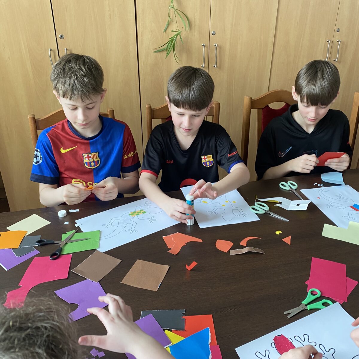 każdy z chłopaków koncentruje się nad swoją jaszczurką