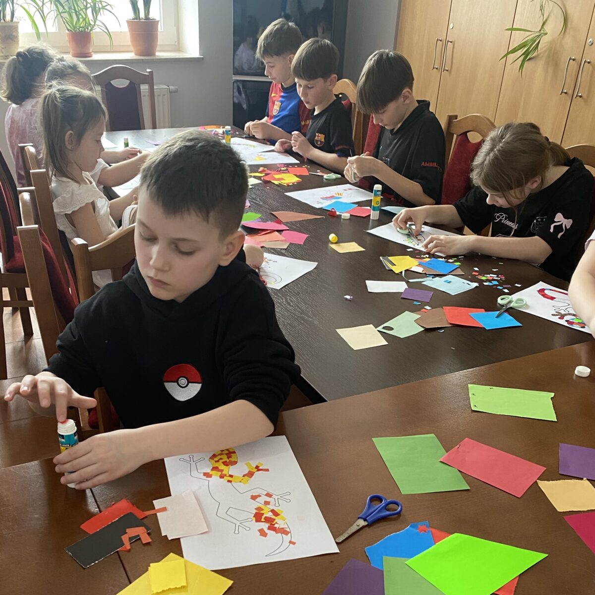 Każde diecko przykleja papierek po papierku na jaszczurke