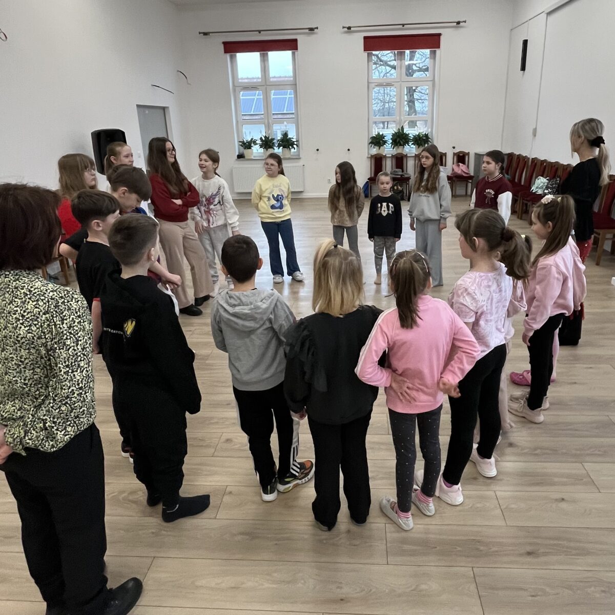 Wszystkie dzieci stoją w kółeczko z pani Lidią i pani Anną