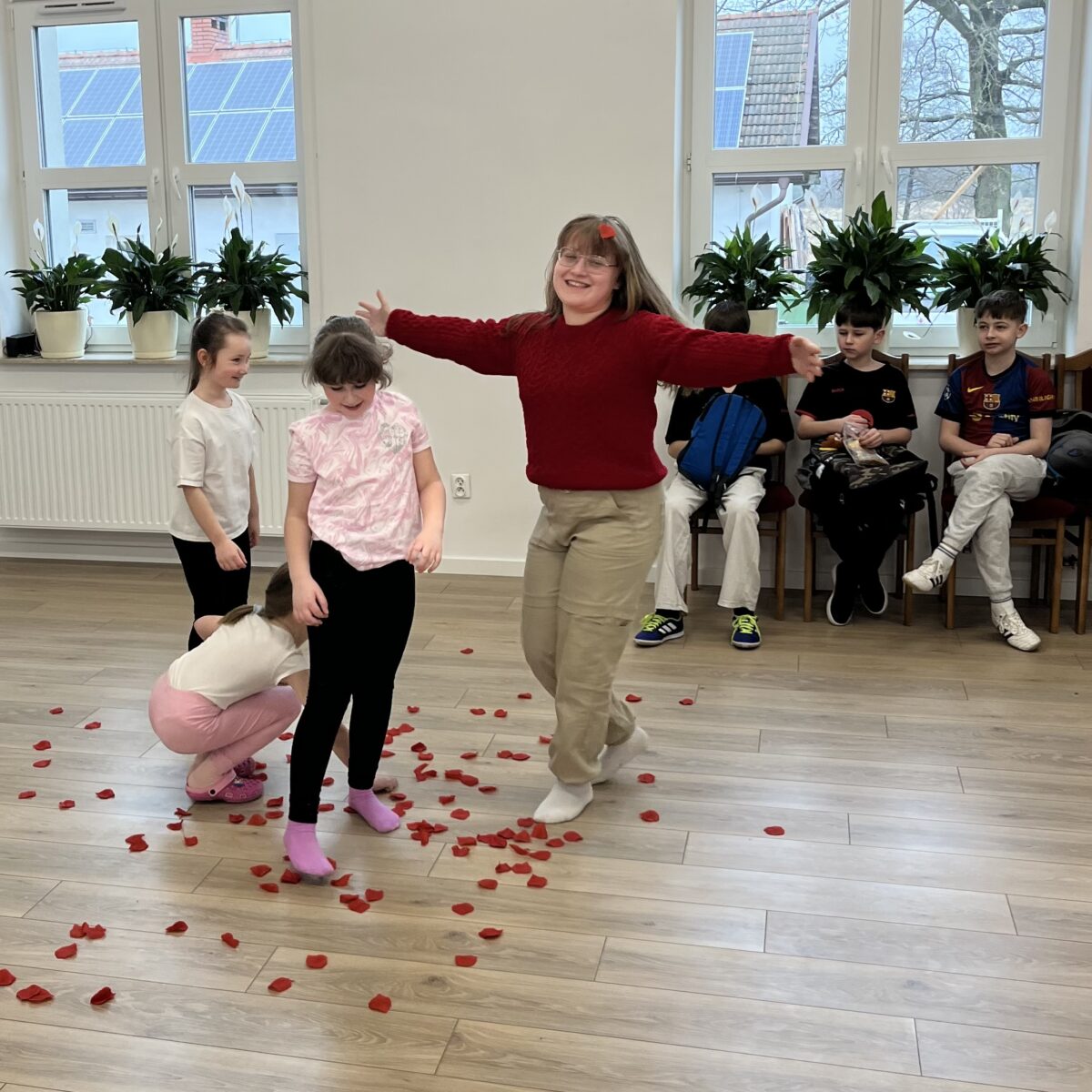 Amelka uśmiecha się i dziewczynki rzucają płatki róży na nią