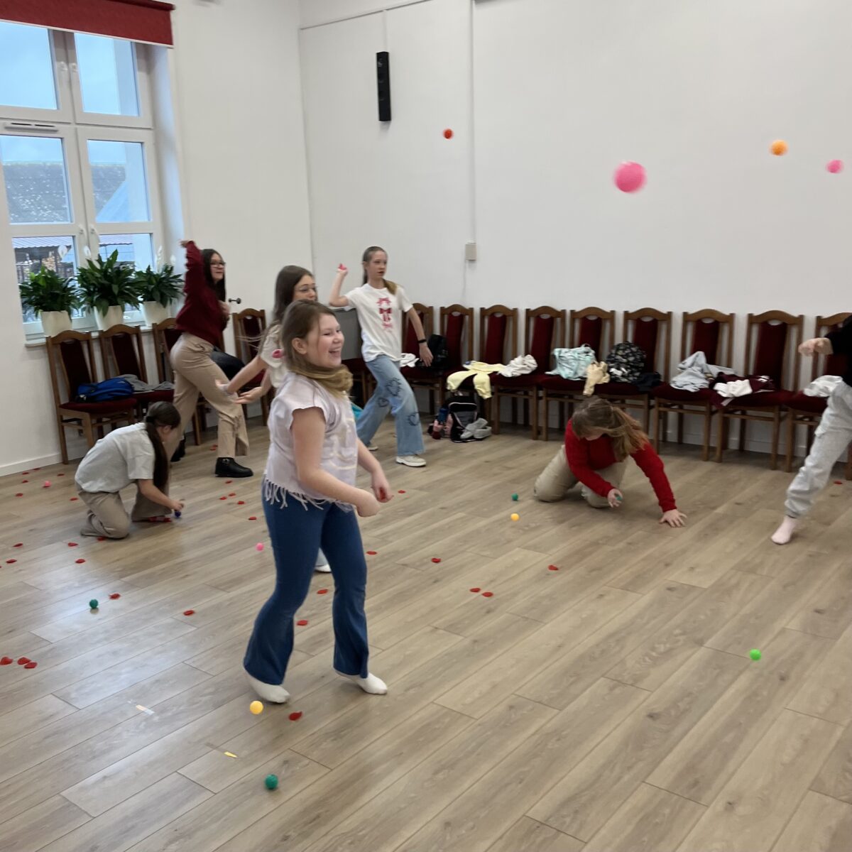 Dziewczyny zbierają piłki na podłodze