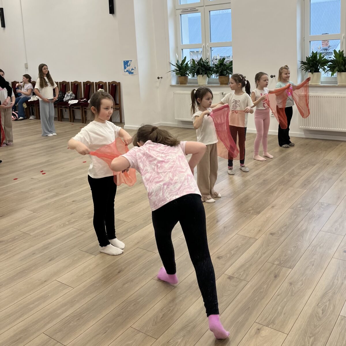 pięć dziewczynek stoją z chustkami czerwonymi, każda jako toreador i Amelka gra role byka, chodząc od jednej chustki do drugiej