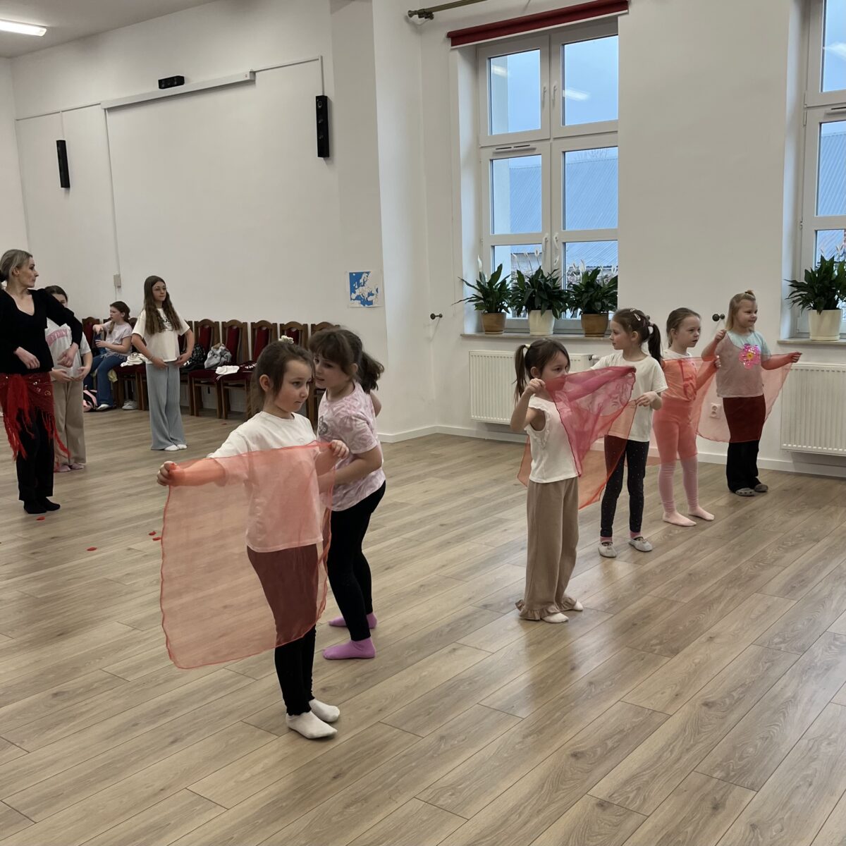 Dziewczyny zmieniają strony chustki w rytmie muzyki