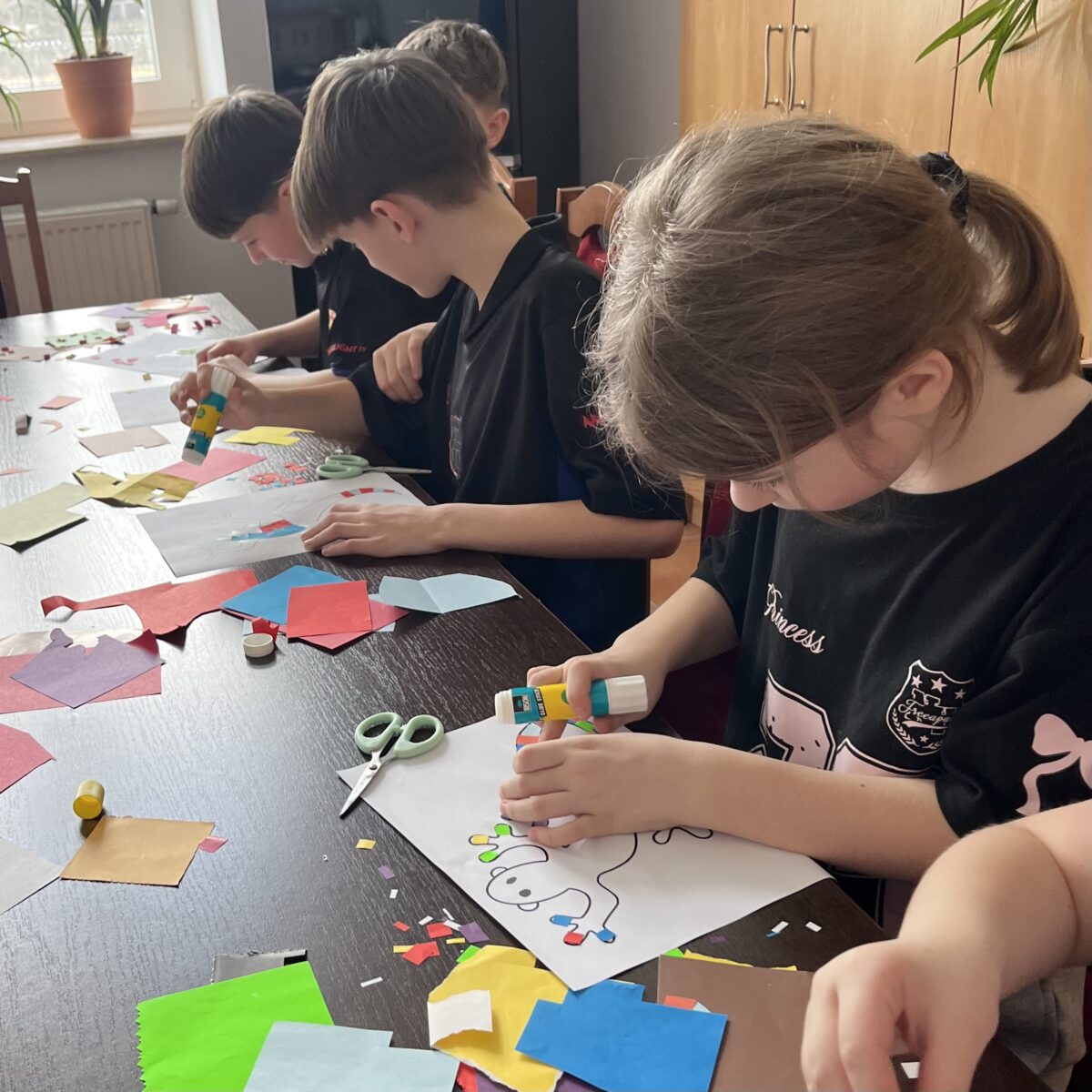 Maja zaczyna robić jaszczurke z kolorowymi paluszkami