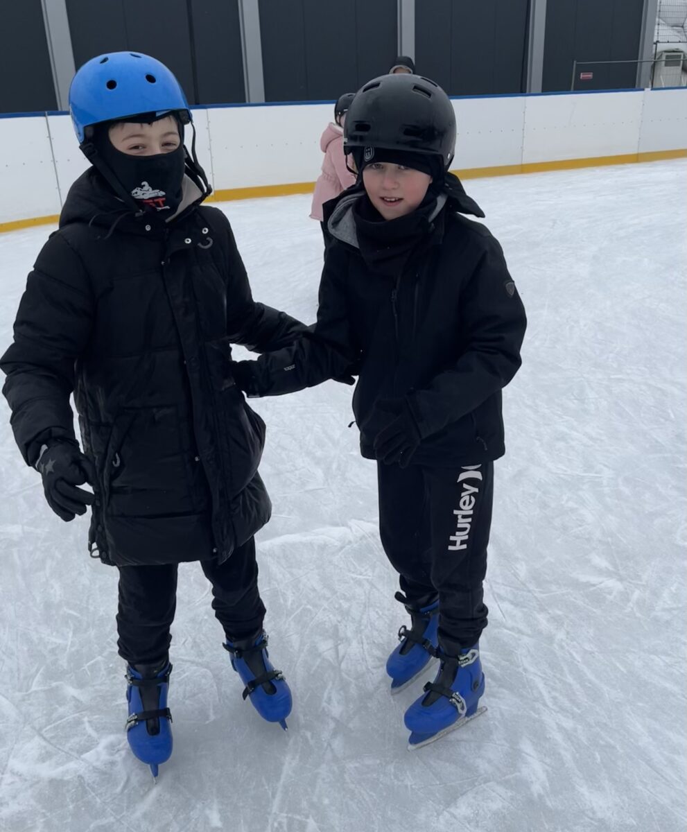 Karol i Michał stoją razem na łyżwach