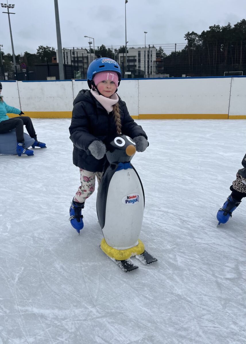 Justyna z uśmiechem jedzie z pingwinem na łyżwach