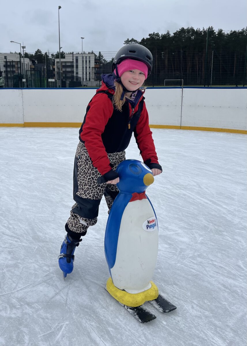 Ania z uśmiechem pcha ten pingwin na łyżwach