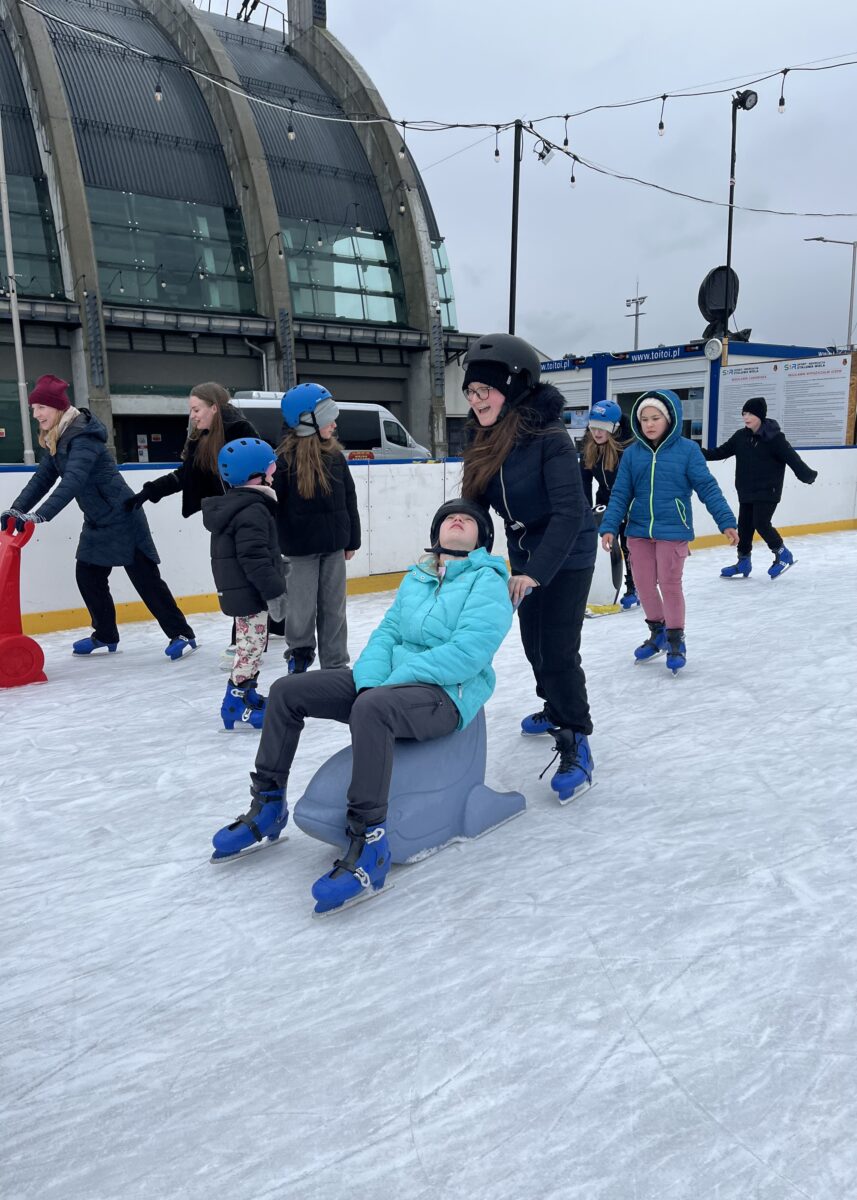 Sandra śmieje się kiedy pcha Sare na wielorybie