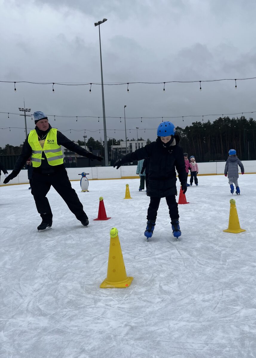 Michał z koleji wykonuje test sprawnościowy na łyżwach gdzie instruktor patrzy aby go ocenić