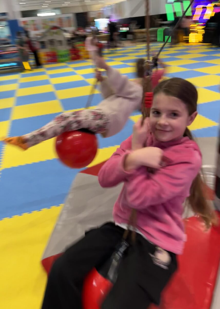 Marcelina z uśmiechem się trzyma kulki która wisi i rusza się w okół punktu