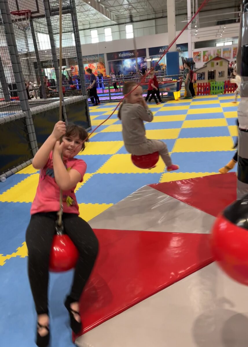 Amelka z uśmiechem się trzyma kulki która wisi i rusza się w okół punktu