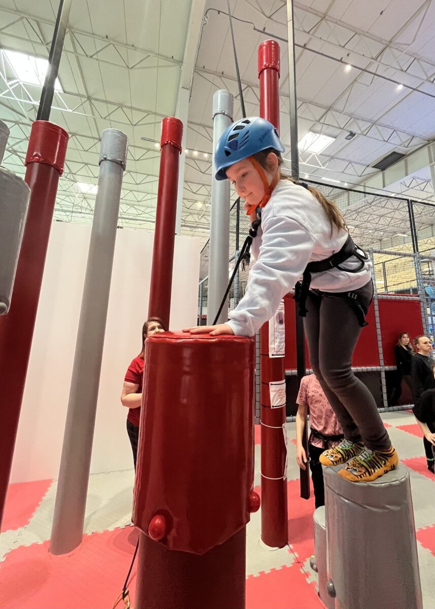 Michalina jest na niskim słupku i schyla się na większym słupie