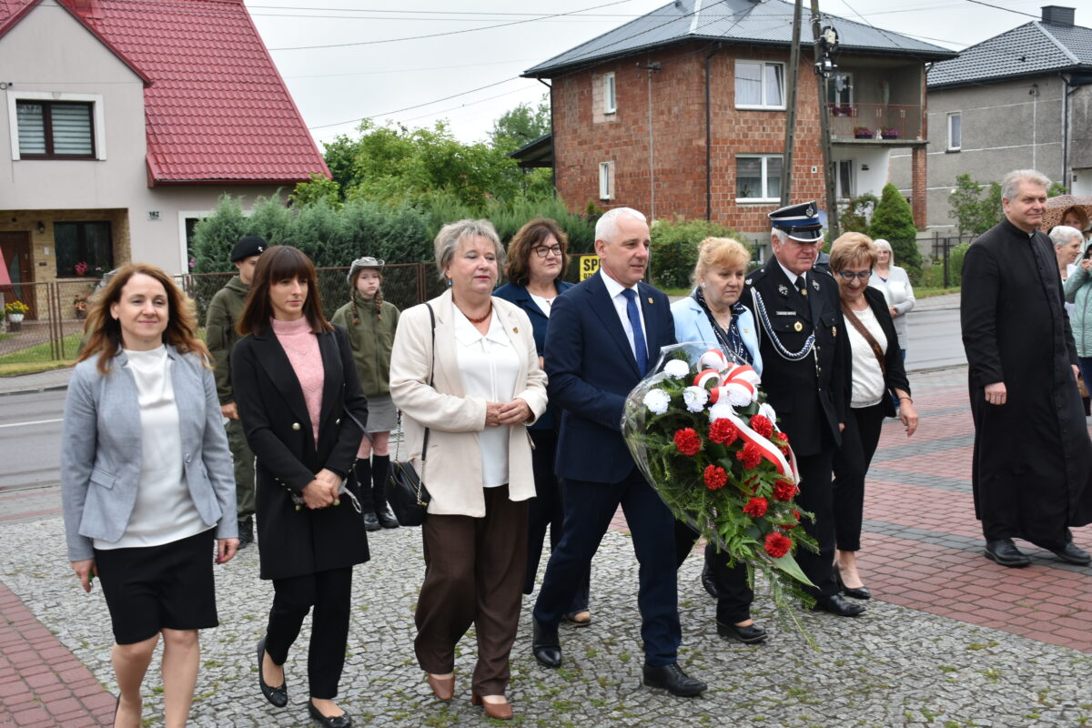 Pan Wójt Gminy Jarocin, pani sekretarz, przezes ochotniczej straży pożarnej w Jarocinie, ks. proboszcz Jarocina i radni Gminy Jarocin idą złożyć kwiaty przy pomniku